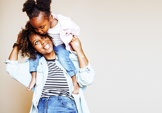 Daughter sitting on the shoulders of her mum