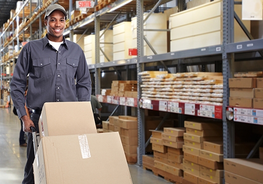 man pushing boxes in a storage facility