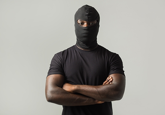 A burglar posing for the camera with his arms crossed