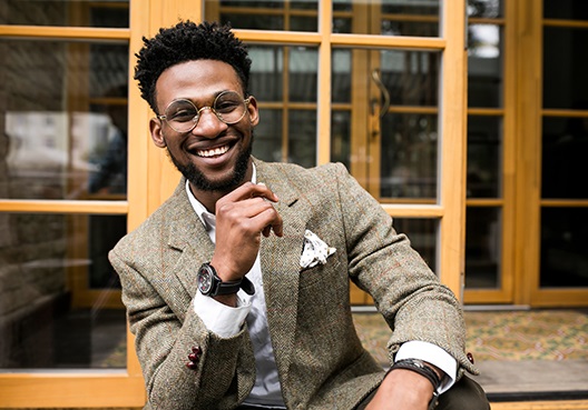 guy sitting on a step smiling at the camera