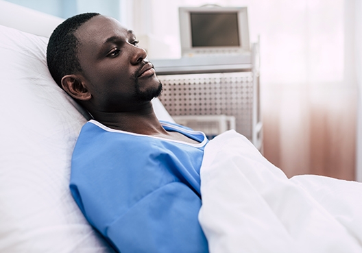 man lying in a hospital bed