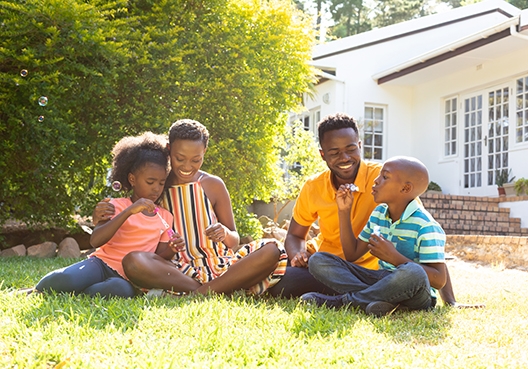 Family sitting on the lawn in front of the house