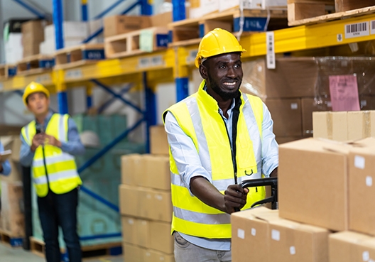 Two workers pushing out boxes from a warehouse