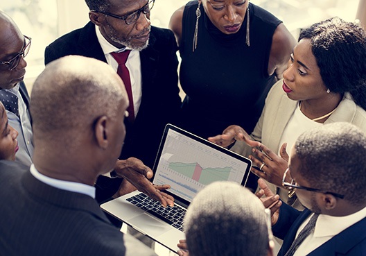 group of colleagues looking at a laptop