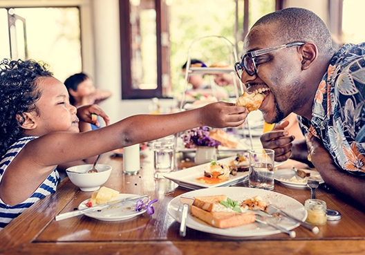 family sitting at a breakfast table eating